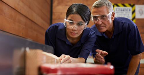 Woodwork Apprentice and instructor using tools.