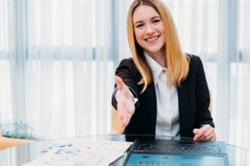 Young business women reaching out to shake hands