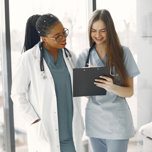 Two nurses looking at a clipboard.