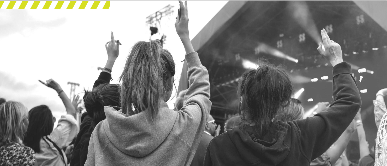 Young women at a concert with their hands raised