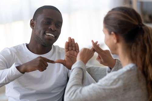 Man and woman talking using sign language.