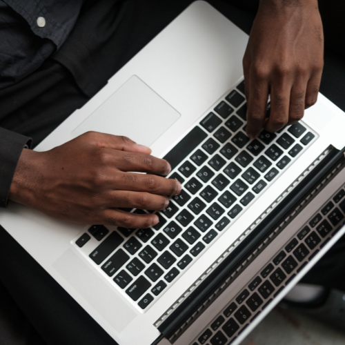 An aerial view of a man typing on a laptop.