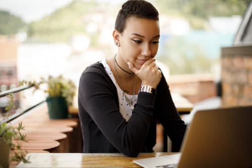 Woman sitting outdoors and using a laptop