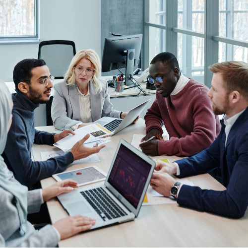 Group of people sitting around a desk.