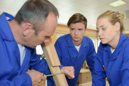 Two apprentices watching carpenter