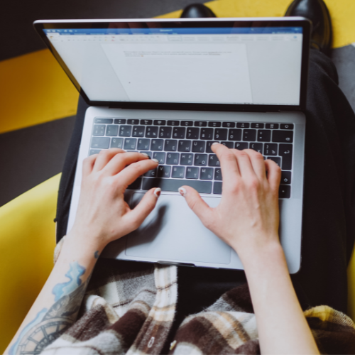 An aerial view of a person typing on a laptop